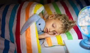 kid sleeping, tucked into bed with a bunny